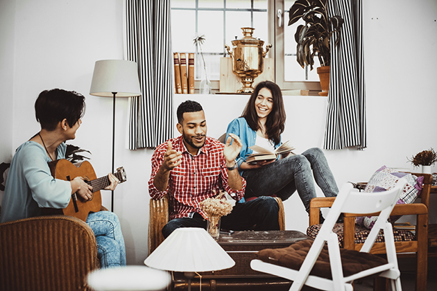 Happy group of friends singing and playing music together